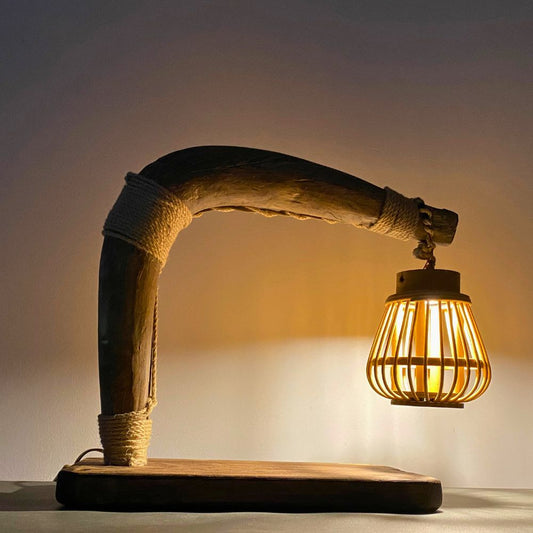 Plowman’s Lantern lit on a farmhouse desk, warm dappled glow from rattan shade